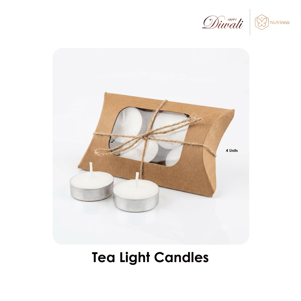 Diwali Premium Gift Hamper featuring four white tea light candles in silver cups, packed in a brown kraft box with a clear window and twine